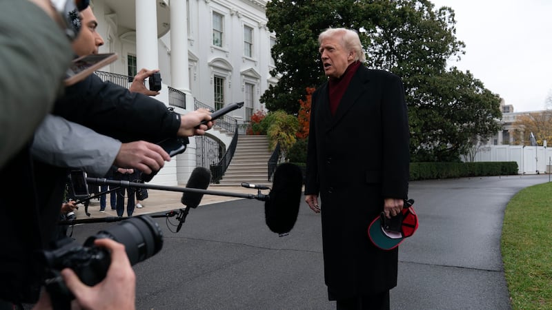 President Donald Trump talks to reporters as he departs from the South Lawn of the White...