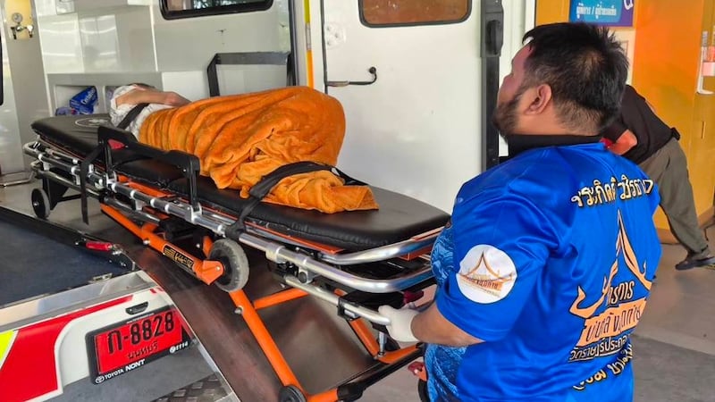 In this Sunday, Nov. 23, 2025, photo, an emergency rescue team transports an elderly woman...