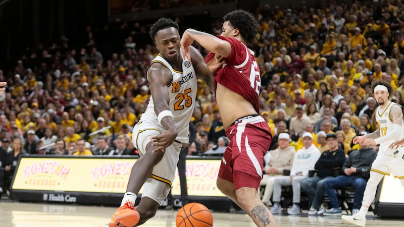 Missouri's Mark Mitchell (25) drives past Arkansas' Malique Ewin, right, during the second...