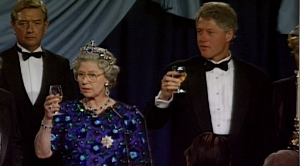 Queen Elizabeth toasts with then-President Bill Clinton during a dinner for the 50th...