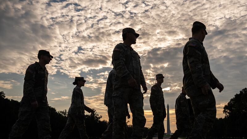 Members of the National Guard walk past the Lincoln Memorial Reflecting Pool before the March...